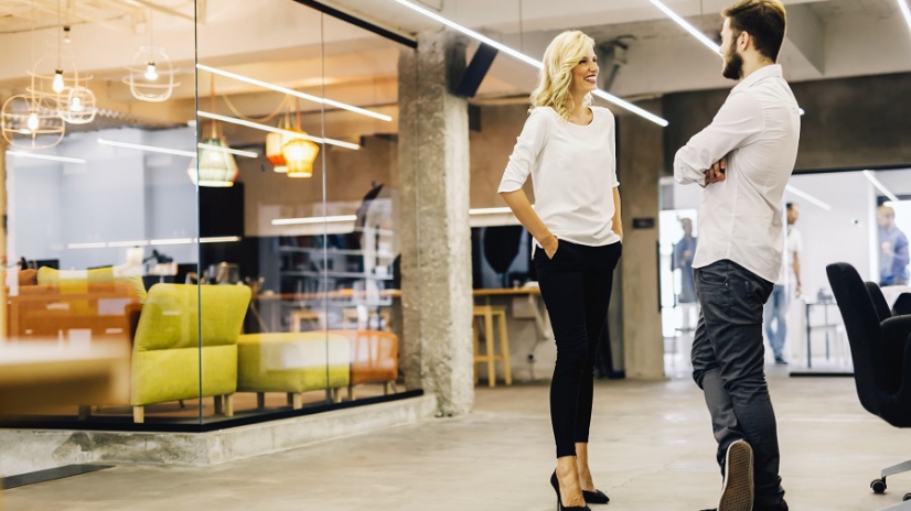 Two intelligent coworkers talking in a modern office